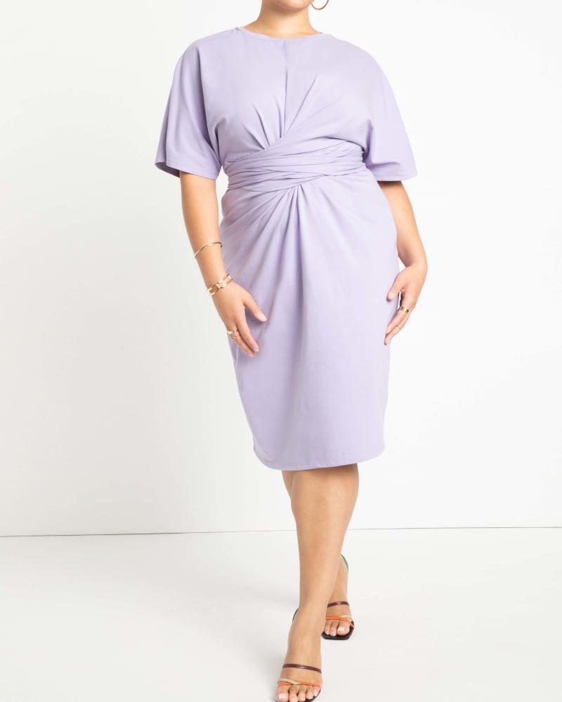 Front of a model wearing a size 28 Cross Front Flutter Sleeve Dress | Purple in Heirloom Lilac by ELOQUII. | dia_product_style_image_id:285458